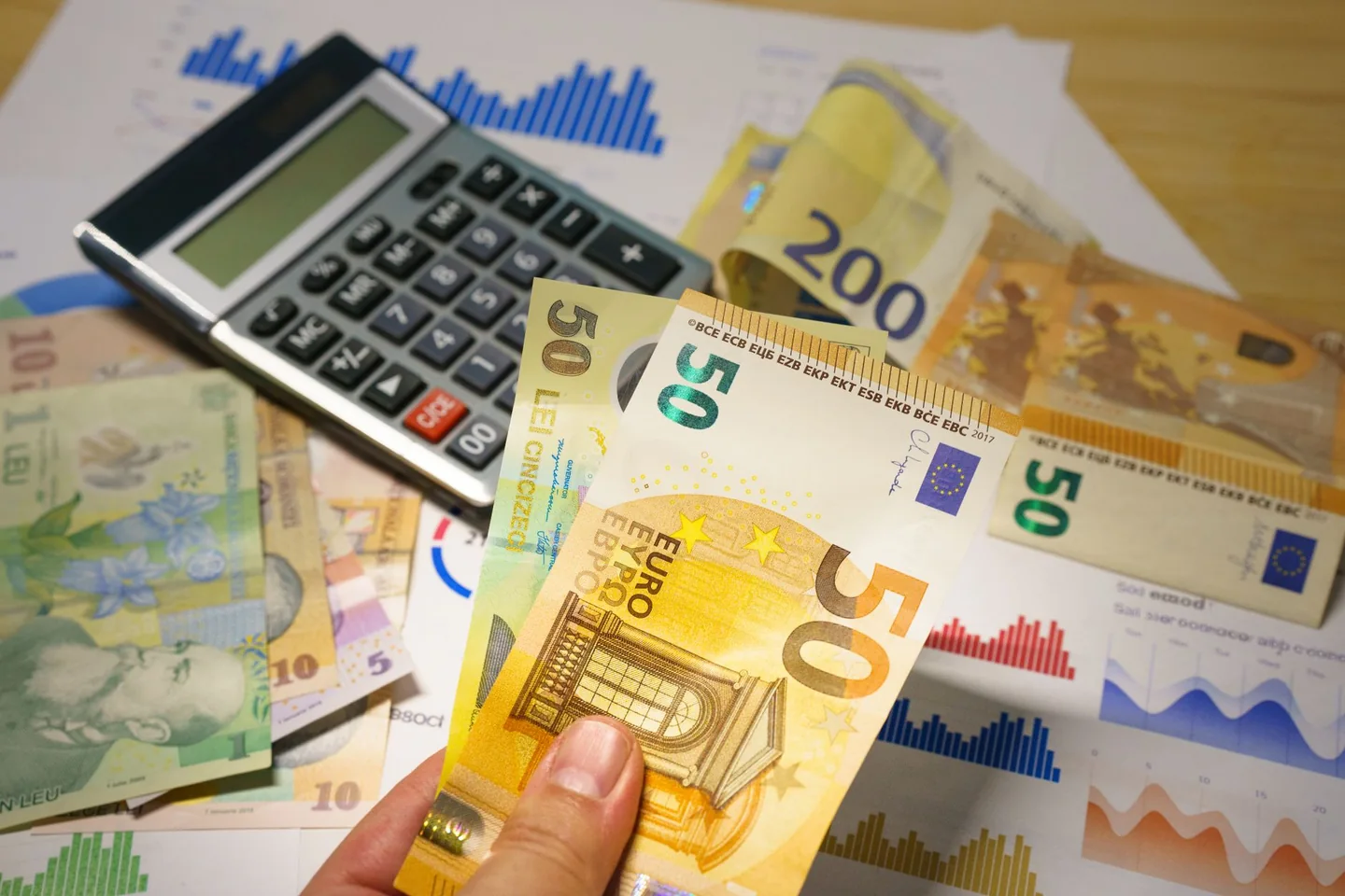Currency notes, calculator and risk worksheet used to compare forex position sizes