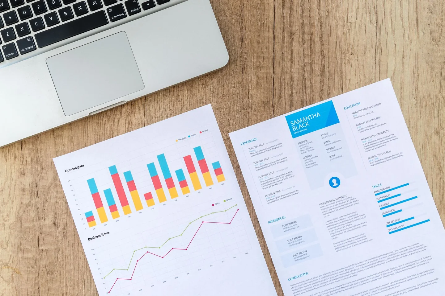 Laptop beside a résumé and employment charts used to illustrate the US jobs report